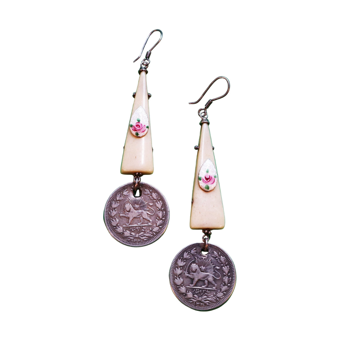 Pair of earrings with vintage coins and decorative elements on a green background