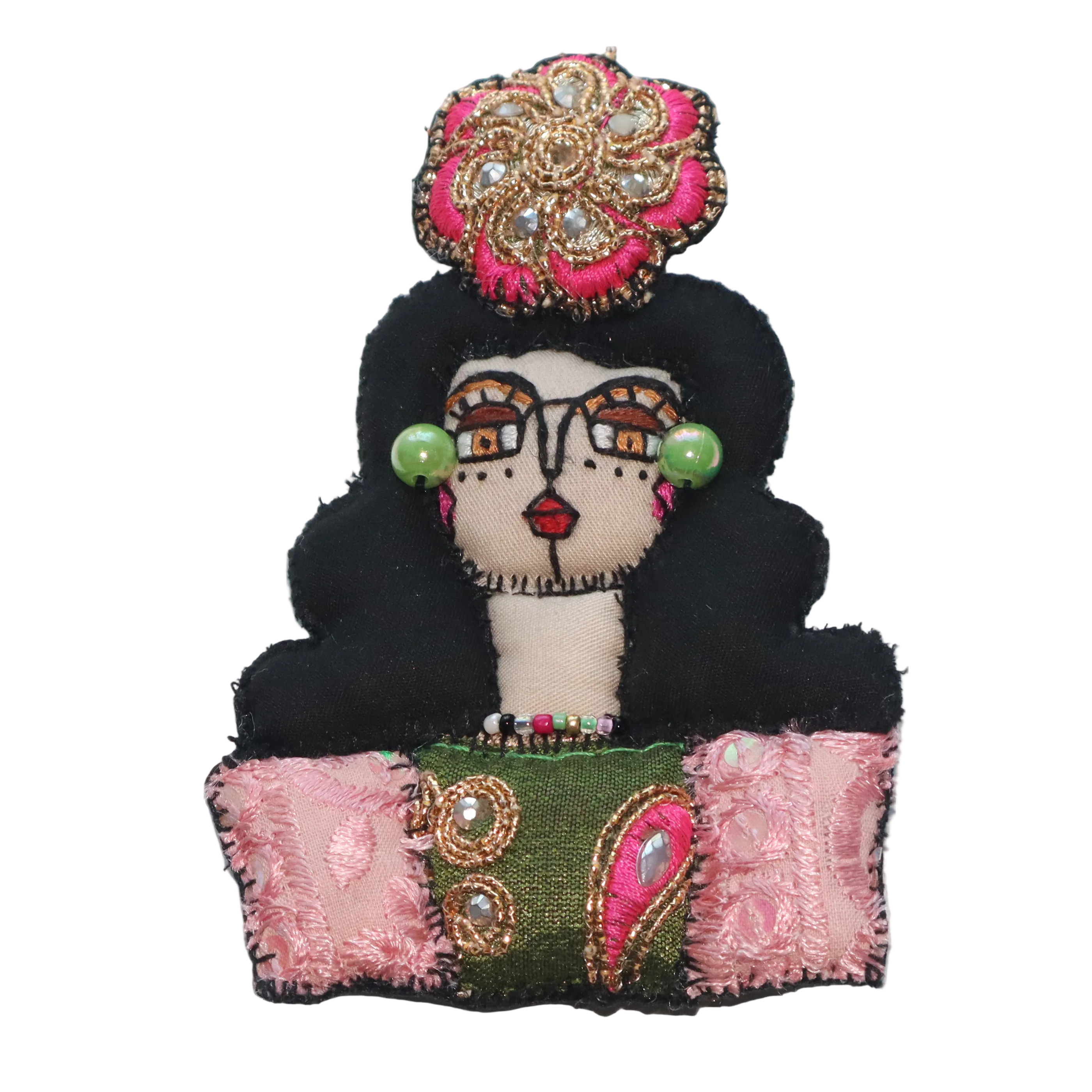 Decorative doll brooch with black hair, colorful headpiece, and a patchwork skirt 